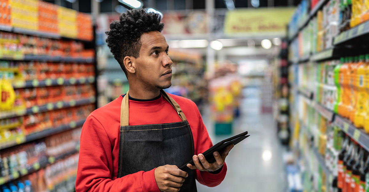 Man scanning item Man confirming inventory on store shelves while holding a tablet